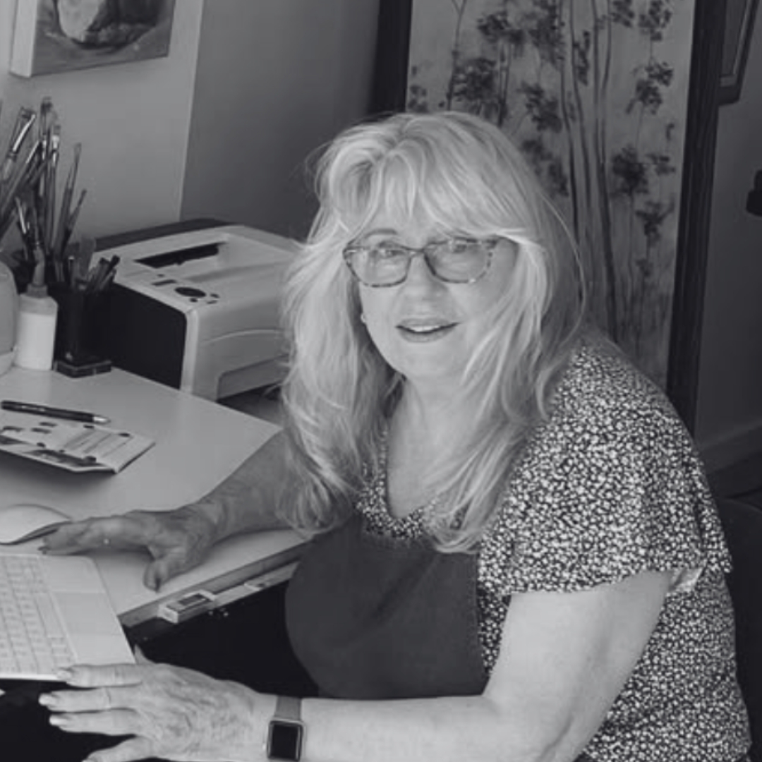 Portrait of Southern Highlands artist and author Marjorie Kay working in her creative studio surrounded by painting and illustration materials.
