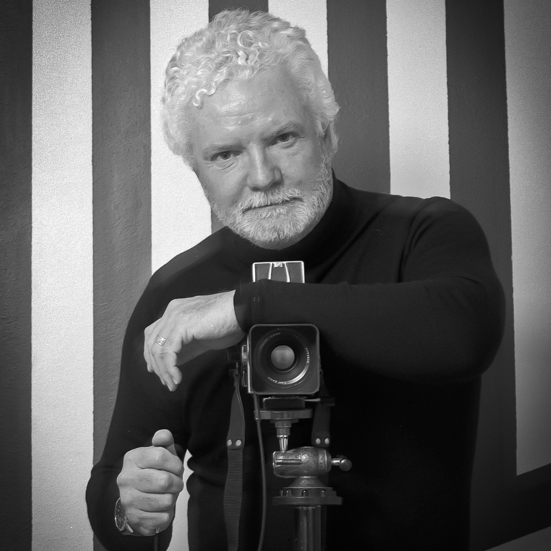 Portrait of award-winning Australian fine art photographer Robert Billington holding a medium format camera in a studio setting.