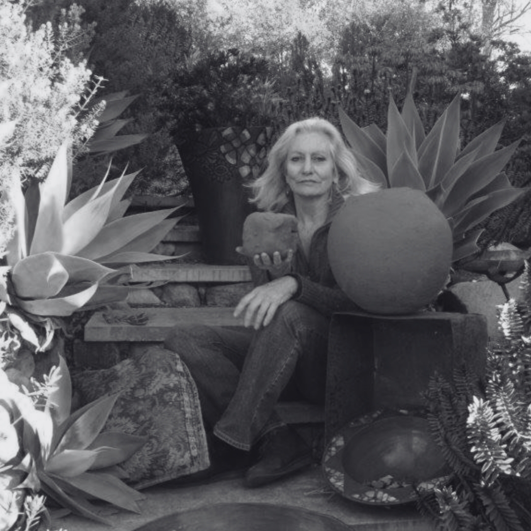 Portrait of Southern Highlands ceramic artist and interior designer Yolande Clarkson surrounded by plants, pottery and natural textures in a garden setting.